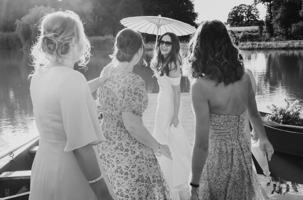 bride with parasol with bridesmaids